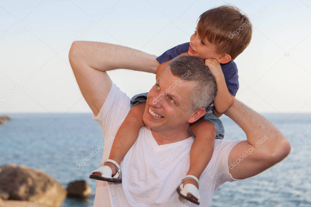 father and son piggyback on summer vacation or holiday