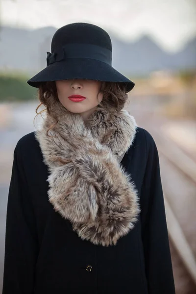 グラマラスな50代のレトロな女性と帽子とコート ストック写真