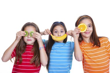 Sağlıklı meyvelerle gülümseyen çocuklar.