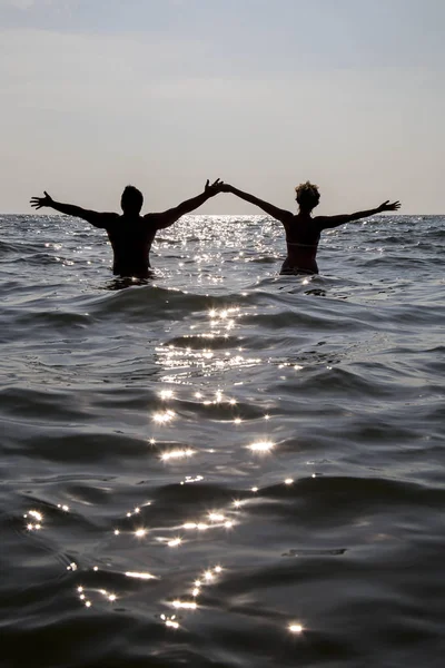 Adam ve kadın güneşi atılmış deniz stand. Yatay olarak,
