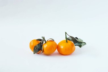 Beyaz arka planda mandalina. Beyaz arka planda yeşil yapraklı Mandarin veya Clementine