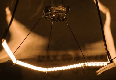 Yakından parlak bir lamba. Lamba yandı. Ampul karanlık bir odada asılı. Enerji konsepti. Ekoloji, enerji çöküşü