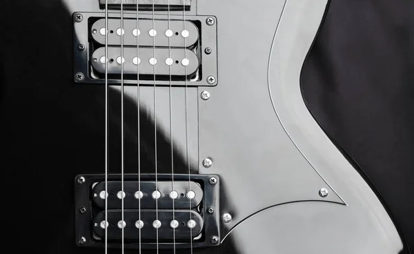 A fragment of a black guitar with steel strings — Stock Photo, Image