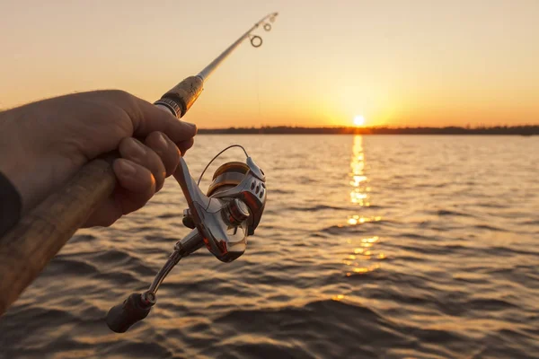 Canne à pêche à la main sur fond de coucher de soleil Images De Stock Libres De Droits