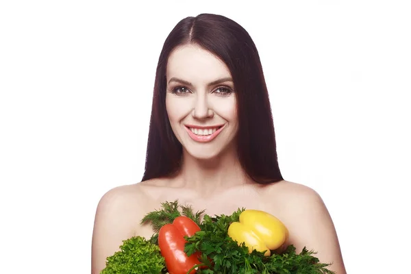 Sporty young girl with a smile. Diet, weight loss. Closes breast with vegetables and greens. — Stock Photo, Image