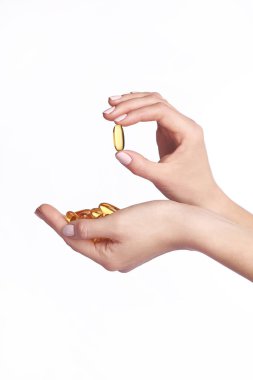 Balık yağı omega 3 kapsülleri elinde. Beyaz arka plan