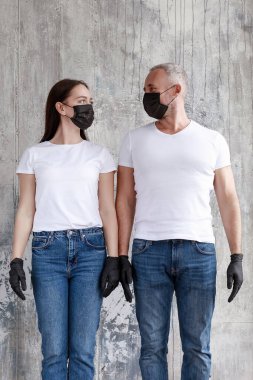 Siyah meedsin maskeli ve siyah lastik eldivenli evli bir çift..