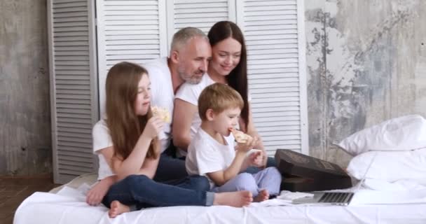 A família em casa em auto-isolamento comer pizza e assistir desenhos animados em um laptop — Vídeo de Stock