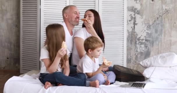 Rodzina w domu na odosobnieniu je pizzę i ogląda kreskówki na laptopie. — Wideo stockowe