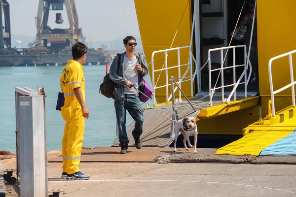 Людина з собакою, виходячи з поромі в морський порт — стокове фото