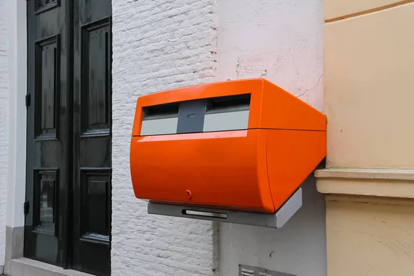 Orange mailbox on the wall of city building — Stock Photo, Image