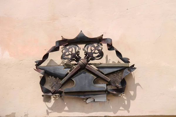 Kovové heraldický znak se dvěma zkříženými klíči na zdi budovy. Mu — Stock fotografie