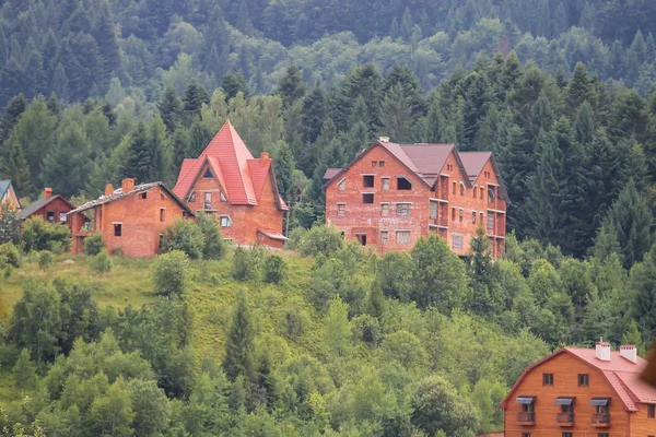 Casas modernas em encostas de montanhas arborizadas. Cárpatos, Reino Unido — Fotografia de Stock