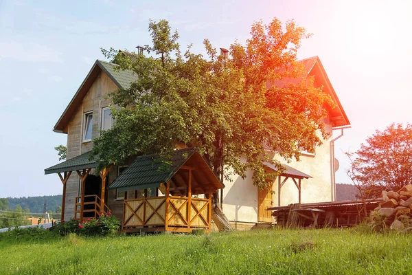 Modern cottage with porch and veranda in sunlight. Carpathians,