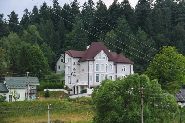 Casas modernas na encosta de montanhas arborizadas. Cárpatos, Ukr — Fotografia de Stock