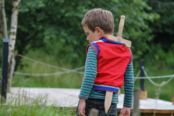 Αγόρι με ξύλινο σπαθί στο καλοκαίρι δασικό πάρκο — Φωτογραφία Αρχείου
