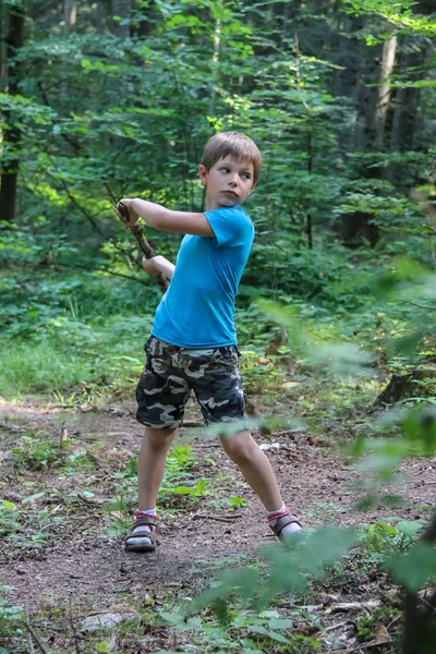 夏の森で木の棒を持つ少年 — ストック写真