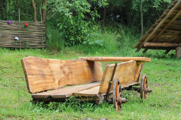 Decorative wooden cart on green grass in Carpatian park — Stock Photo, Image