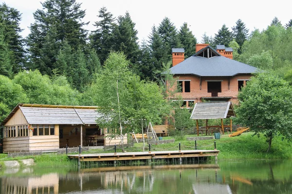 Moderní domek a altánem na břehu jezera v ukrajinské Carpat — Stock fotografie