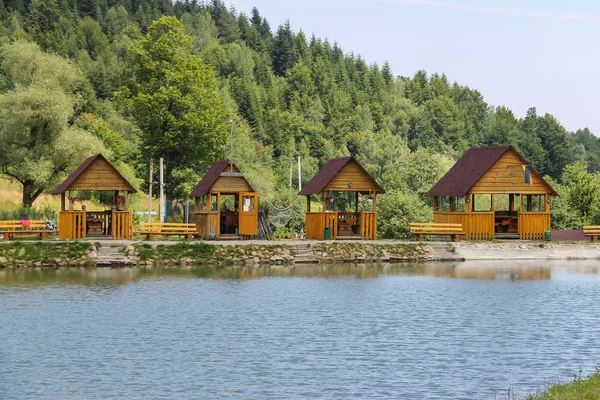 Dřevěné altány na břehu jezera v ukrajinských Karpatech — Stock fotografie