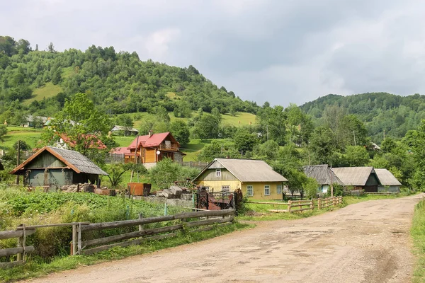 Casas rurais em declive de montanhas arborizadas. Cárpatos, Ucrânia — Fotografia de Stock