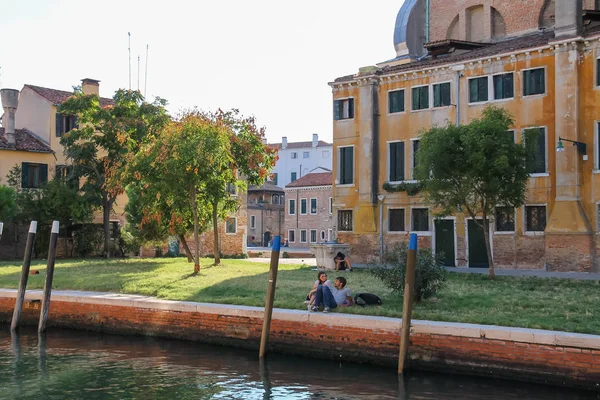 Turistas descansando em pequeno parque perto de água em Veneza, Itália — Fotografia de Stock