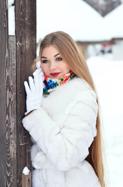 Flickan med långt hår på vintern, hon i en vit päls kappa. — Stockfoto