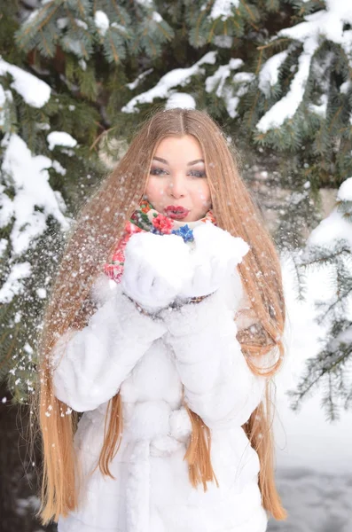 Das Mädchen mit den langen Haaren im Winter, sie im weißen Pelzmantel. — Stockfoto