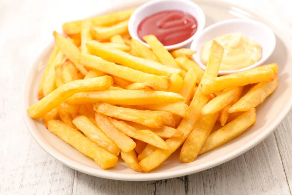 Batatas fritas em fundo de madeira — Fotografia de Stock