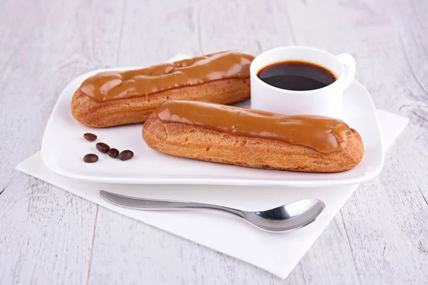 Coffee cup with coffee eclairs — Stock Photo, Image