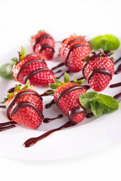 Strawberries with chocolate on white plate — Stock Photo, Image
