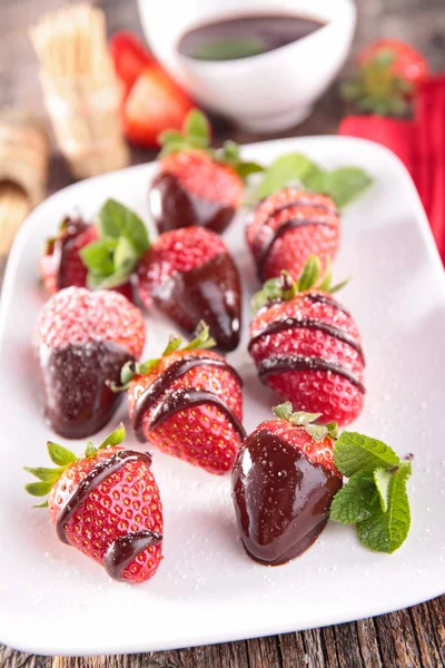 Aardbeien met chocolade op witte plaat — Stockfoto