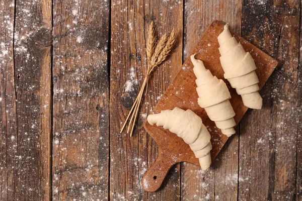 Rohe Croissants auf Holztisch — Stockfoto
