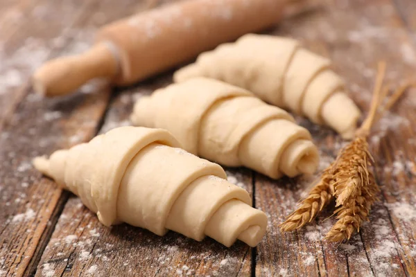 Raw croissants on wooden table — Stock Photo, Image