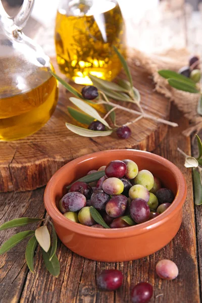 Olives and oil on table — Stock Photo, Image
