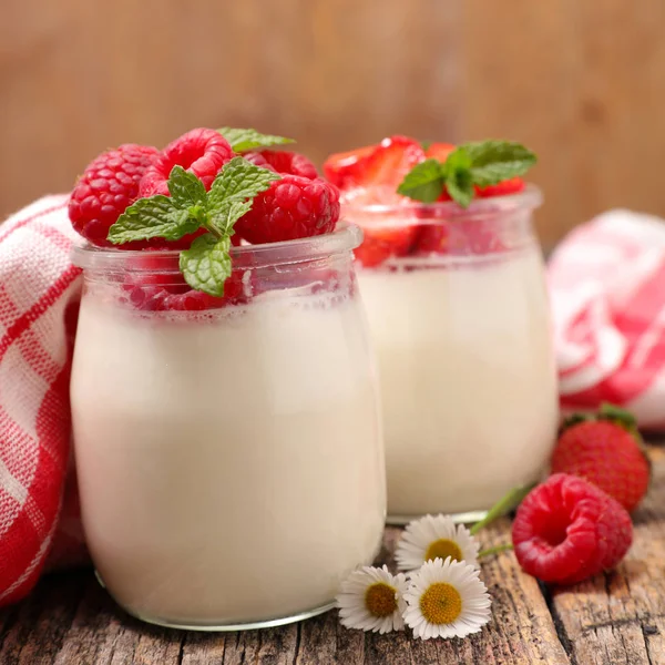 Yogurt y frambuesas maduras en vidrio —  Fotos de Stock