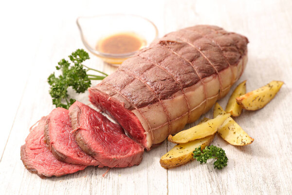 Sliced roast beef on wooden kitchen table