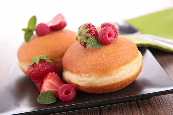 Donuts con bayas en el plato —  Fotos de Stock