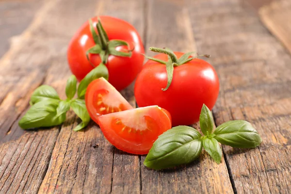 Свежие помидоры и зеленые листья — стоковое фото