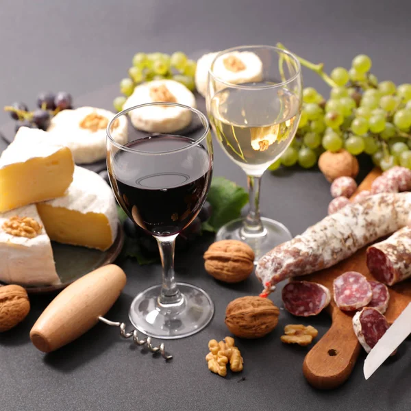 Wine glasses with cheese and salami — Stock Photo, Image