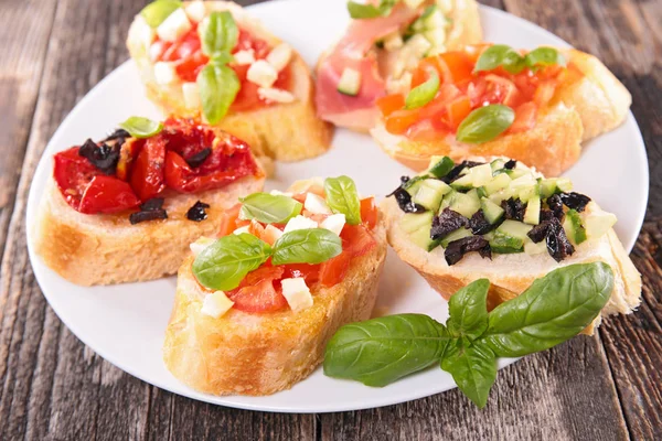 Bruschettas on white plate — Stock Photo, Image