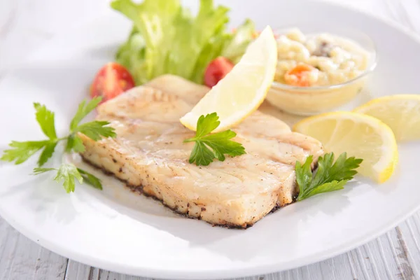 Fish fillet with sauce and lemon — Stock Photo, Image