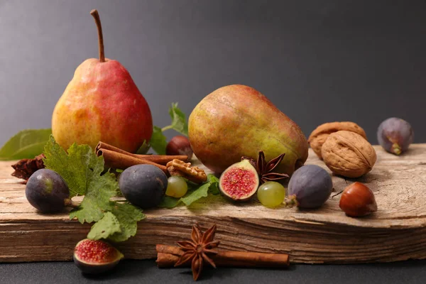 Druiven en vijgen op houten plank — Stockfoto