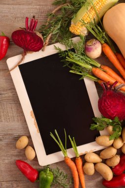 yazı tahtası ve ahşap arka plan üzerinde çiğ sebze