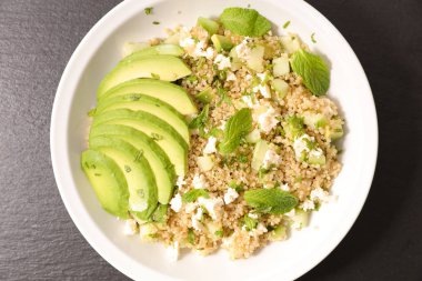 Vejetaryen salata quinoa koyu arka plan üzerinde beyaz plaka ile