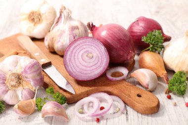 Kırmızı soğan ve sarımsak bıçak ile kesme tahtası üzerinde