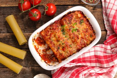 Sığır eti ve domates sos ile canneloni ahşap masa üzerinde görmek