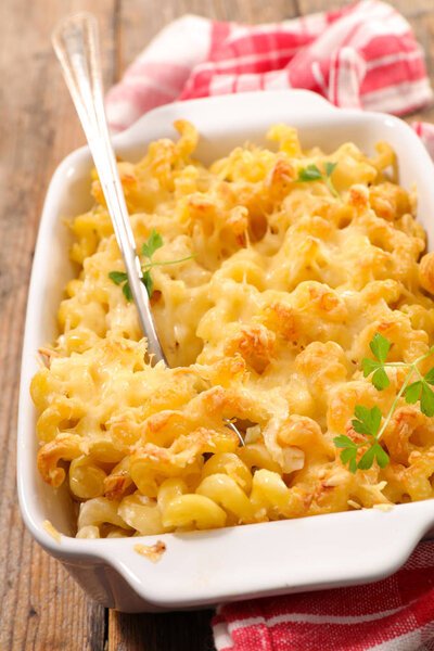 Крупный план выпечки макарон со сливками и сыром на деревянном столе
