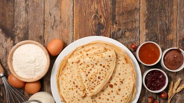 Close-up view of pancakes with ingredients on wooden table  on wooden table