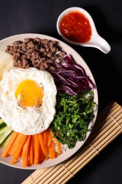 Bibimbap ahşap masa, üstten görünüm, Kore gıda üzerine plaka üzerinde